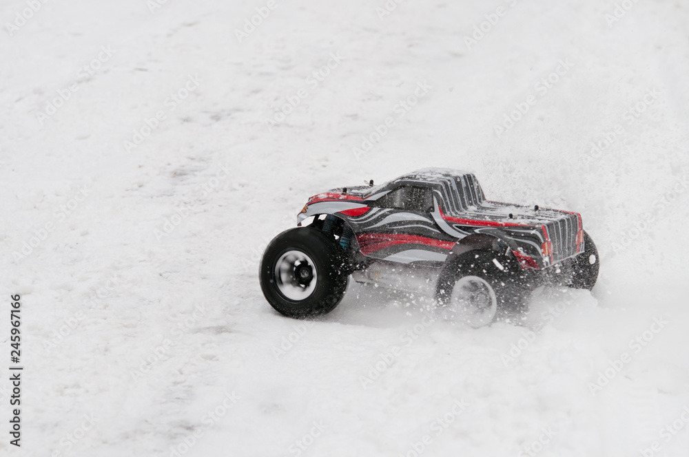 Radio-controlled car starts on a snowy road.