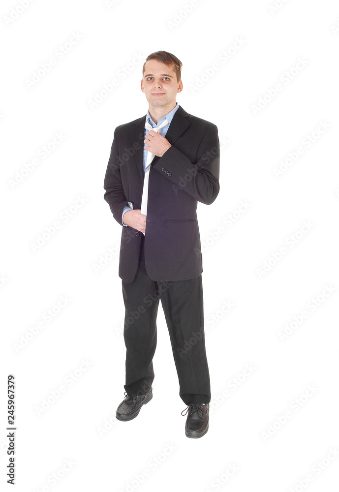 Young man standing in a suit fixing his tie Young man standing in a suit fixing his tie