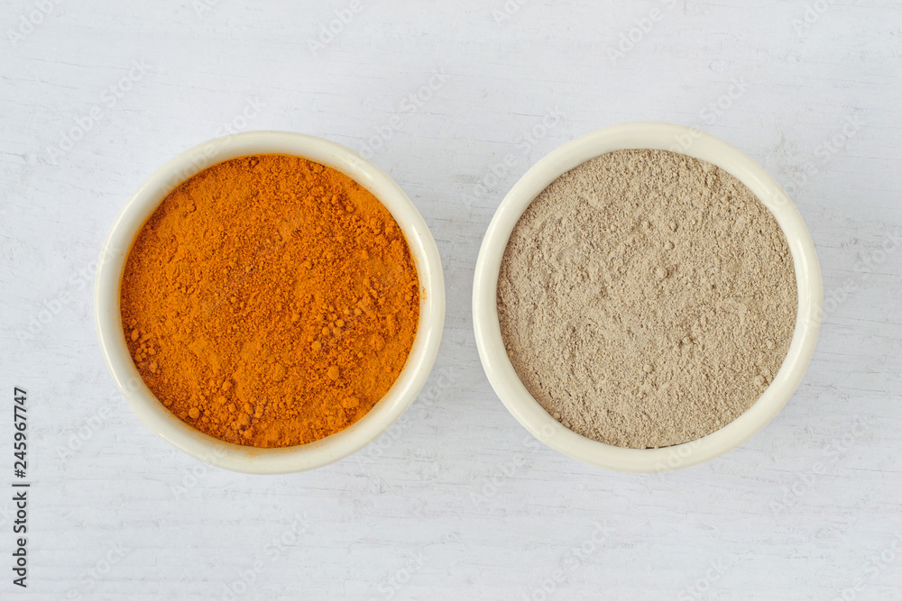 Homemade face mask made out of turmeric and moroccan rhassoul (ghassoul) clay on wooden background Homemade face mask made out of turmeric and moroccan rhassoul (ghassoul) clay on wooden background
