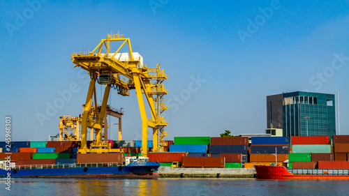 Container ship in export and import business and logistics. Shipping cargo to harbor by crane. Water transport International. 
