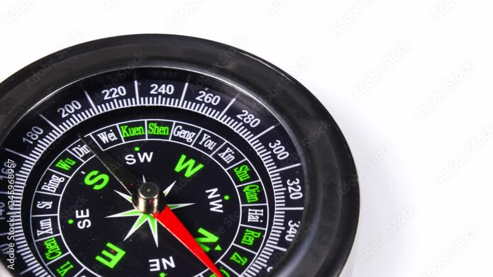 Close up compass rotating on white background. Travel, tourism and exploration Close up compass rotating on white background. Travel, tourism and exploration