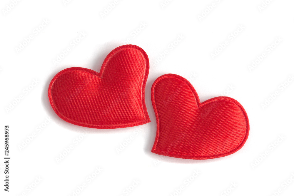 Two red fabric hearts sit close together on a clean white background. Concept of: Romantic closeness Two red fabric hearts sit close together on a clean white background. Concept of: Romantic closeness