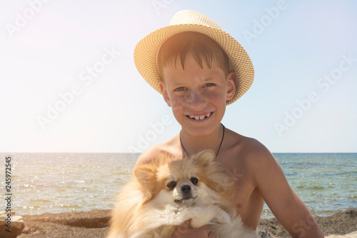 Happy 8 year old boy hugging his dog Pomeranian Shpitz friendship beetwin people and dog photo