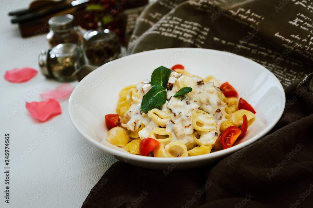 Cooked pasta with a cream sauce and roasted chicken cured with emmental. Cooked pasta with a cream sauce and roasted chicken cured with emmental.