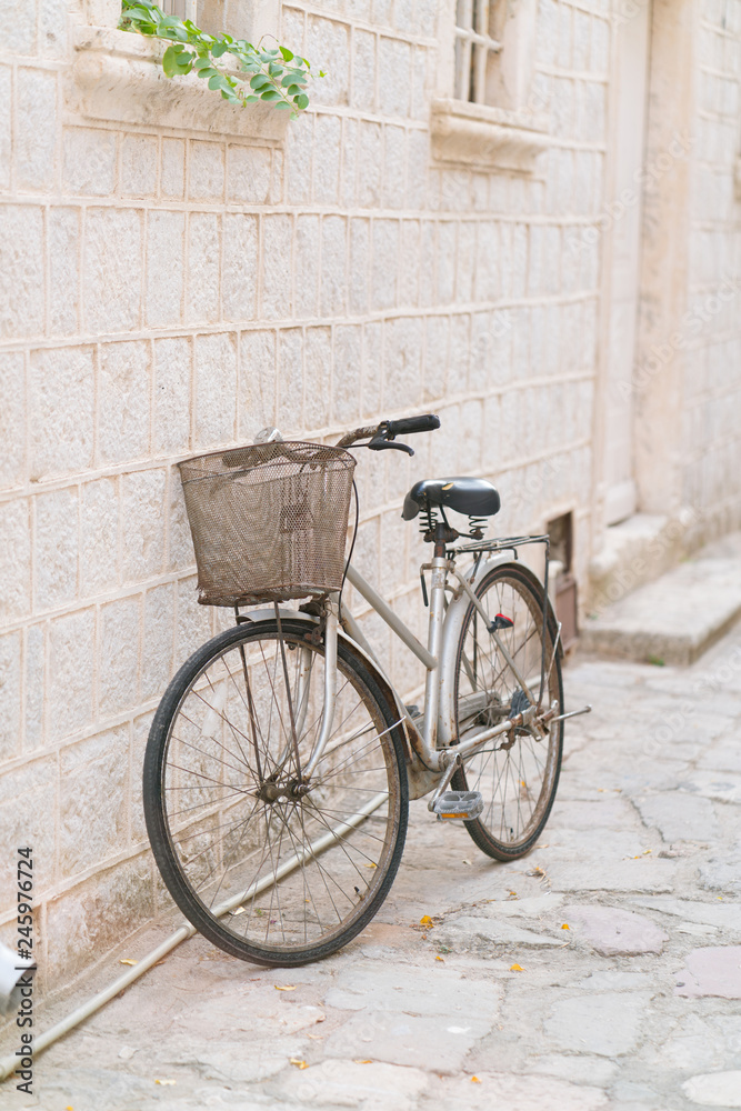 old rusty vintage bicycle leaning against a stone wall