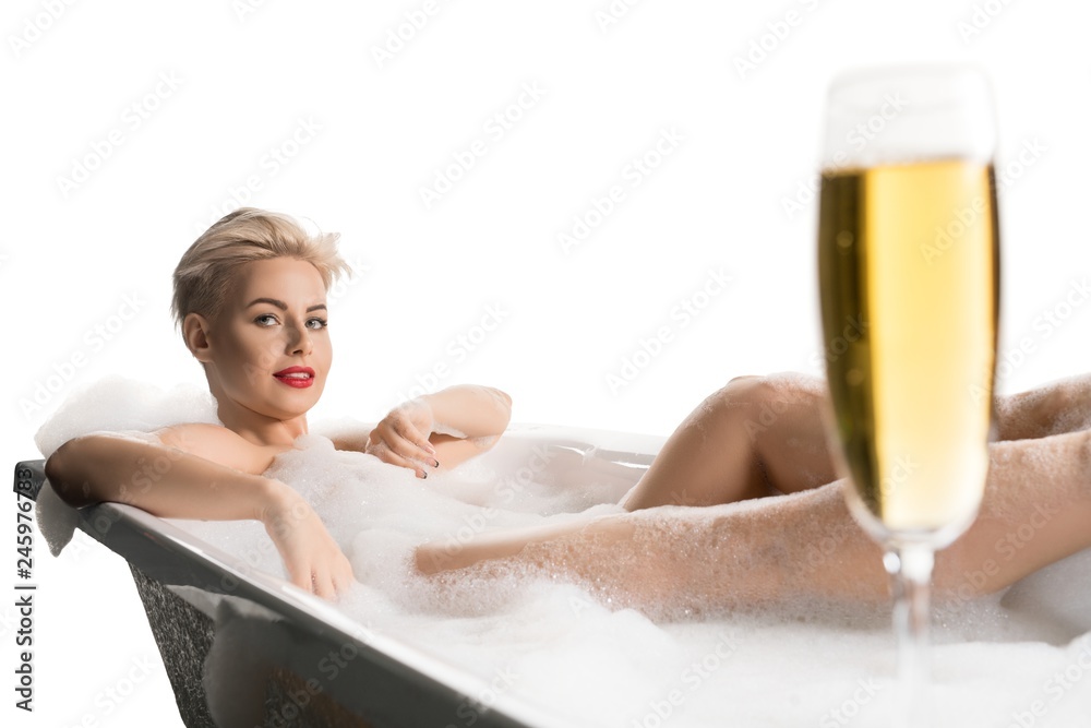 Obraz premium Beautiful model in bubble bath with glass of champagne