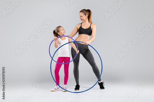 Beautiful woman and her daughter with hula hoop