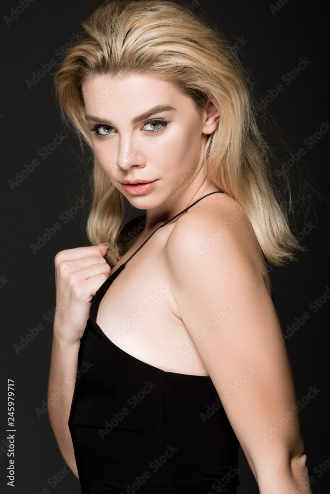 beautiful blonde girl in black dress posing isolated on black beautiful blonde girl in black dress posing isolated on black