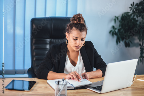 Beautiful girl, developing a project plan and concept. A girl draws a website design on a laptop. A student writes a message on business growth in a messenger. photo