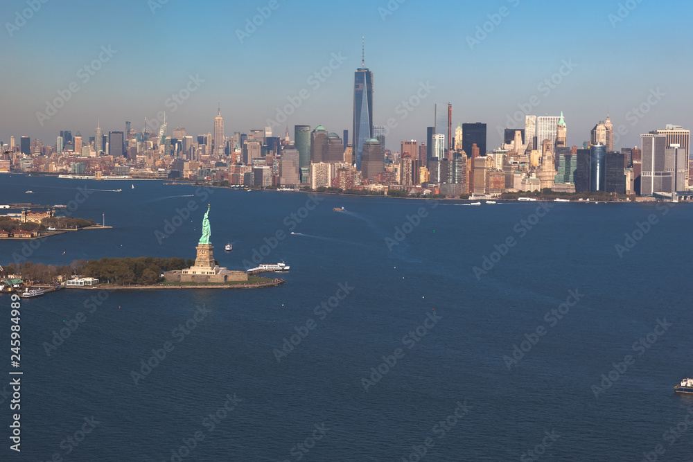 Helicopter view of statue of liberty on background downtown Manhattan. Aerial view. Liberty IslandManhattan, New York City, New York.