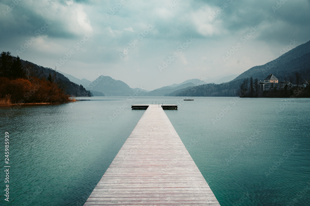 Fototapeta premium Drewniane molo z czystym jeziorem w Alpach latem