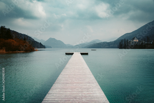 Wooden pier with clear lake in the Alps in summer