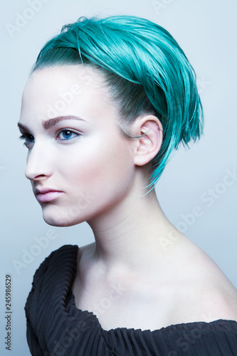 Side view of young woman with blue hair