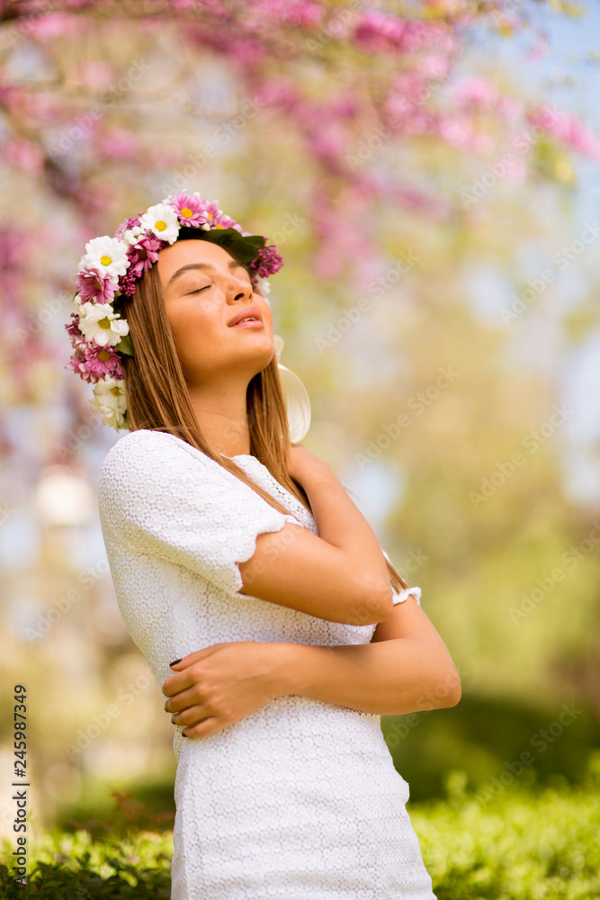 Portrait of young woman with wreath of fresh flowers on head Portrait of young woman with wreath of fresh flowers on head