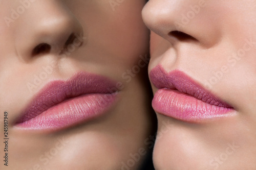Close up of a young woman's rose colored lips reflecting in a mirror. photo