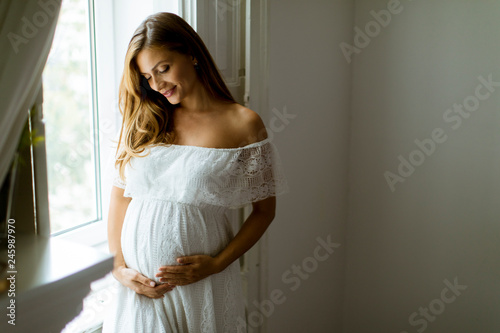 Young pregnant woman standi...