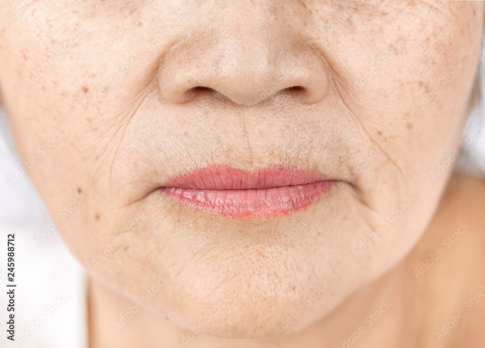 Fototapeta premium bliska zmarszczek skóry i piegi starej twarzy azjatyckiej kobiety