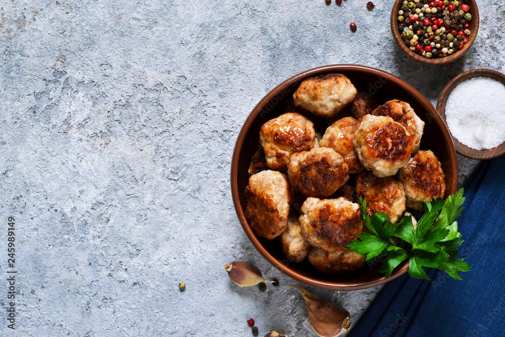 Fototapeta premium Meat balls with spices on a concrete background. View from above.