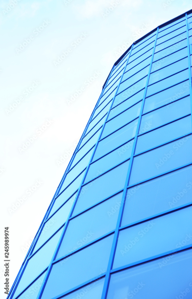 Modern office building with tinted windows against blue sky Modern office building with tinted windows against blue sky