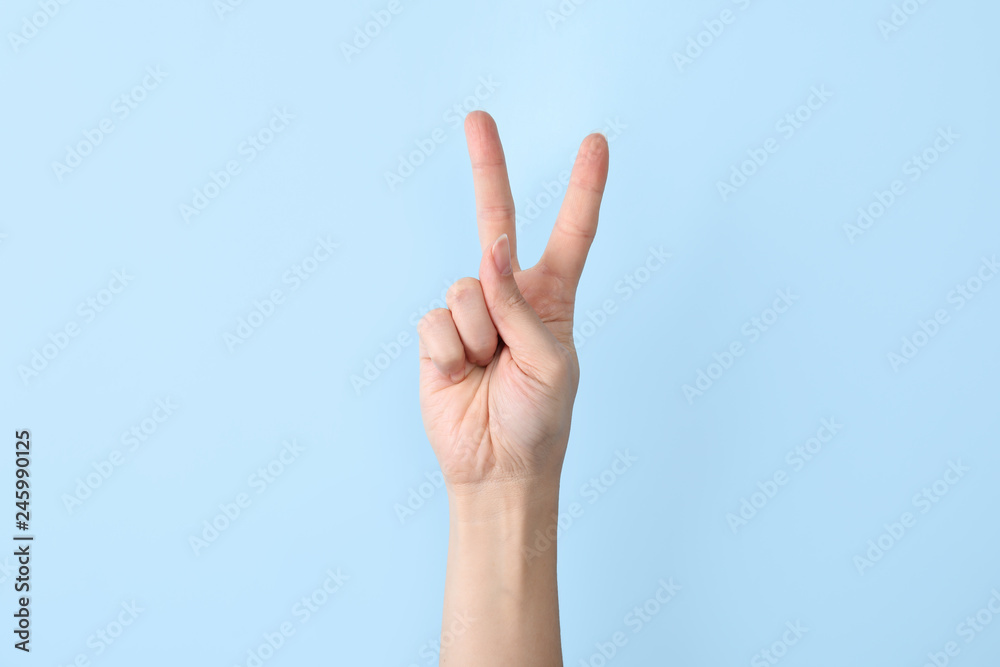 Woman showing V letter on color background, closeup. Sign language - obrazy, fototapety, plakaty 
