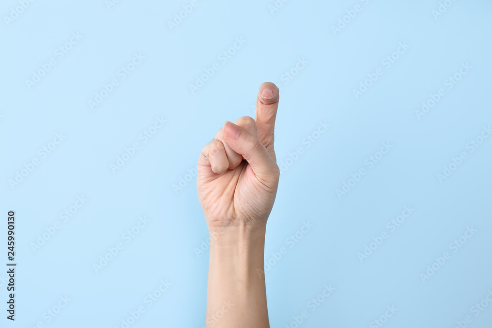 Woman showing X letter on color background, closeup. Sign language Woman showing X letter on color background, closeup. Sign language