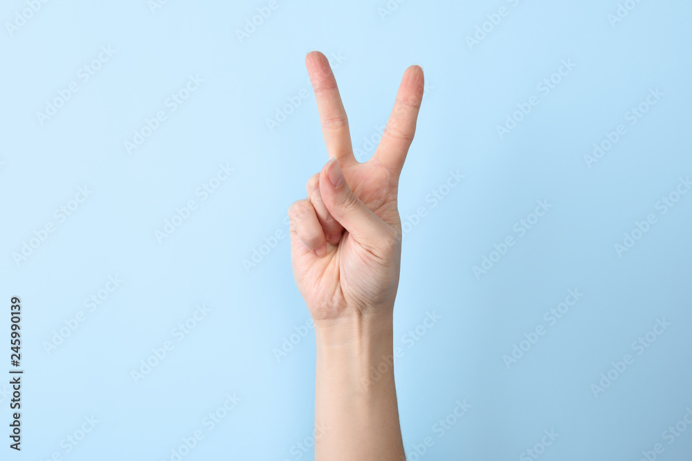 Woman showing number two on color background, closeup. Sign language Woman showing number two on color background, closeup. Sign language