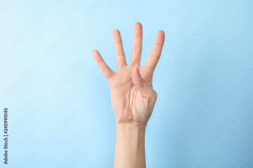 Woman showing number four on color background, closeup. Sign language - obrazy, fototapety, plakaty 