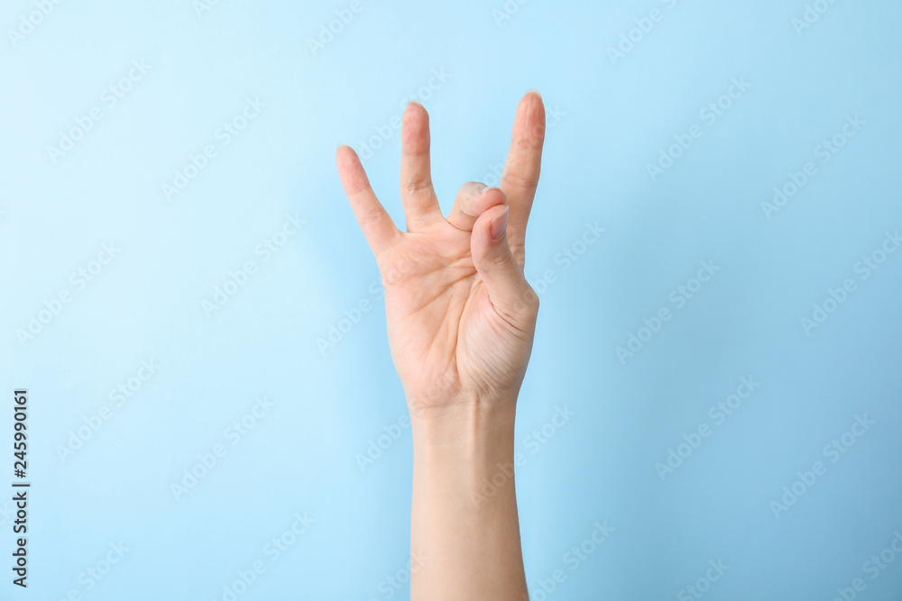 Woman showing number eight on color background, closeup. Sign language Woman showing number eight on color background, closeup. Sign language
