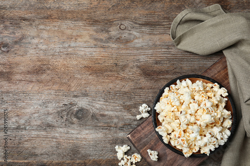 Flat lay composition with popcorn and space for text on wooden background