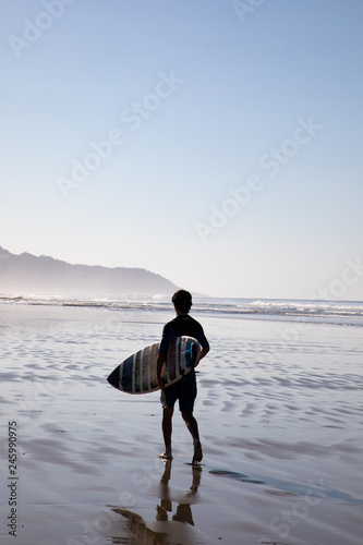 Photography surfer walking on the beach in santa teresa in costa rica