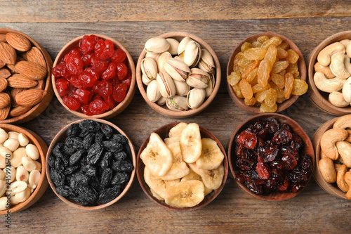 Composition of different dried fruits and nuts on wooden background, top view