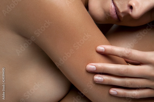 Closeup of a naked woman hugging her legs, cropped. photo