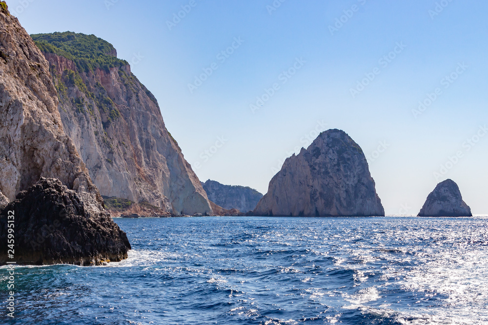 Beautiful rock formations sticking out of the shimmering deep blue sea around the island, Zakynthos, Greece