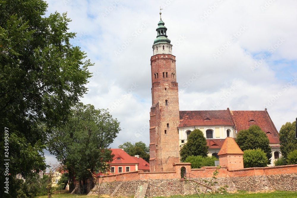 Church behind defence city wall with tower in Wschowa Poland