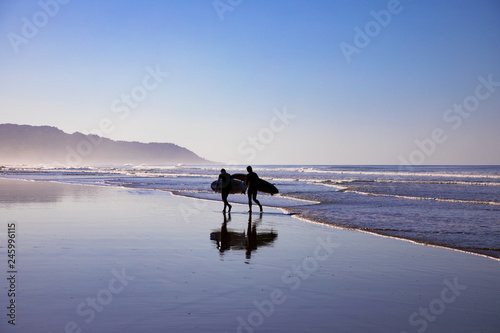 surfer walking on the beach in santa teresa in costa rica photo