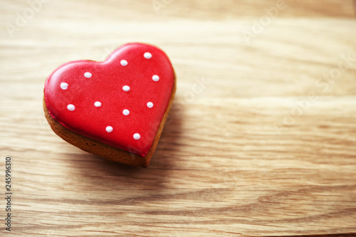 gingerbread in the form of a red heart on a wooden background