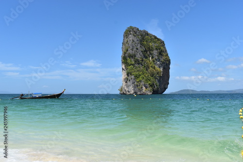Beautiful big rock at Poda Island and a wooden long tail boat in Krabi, Thailand, Asia