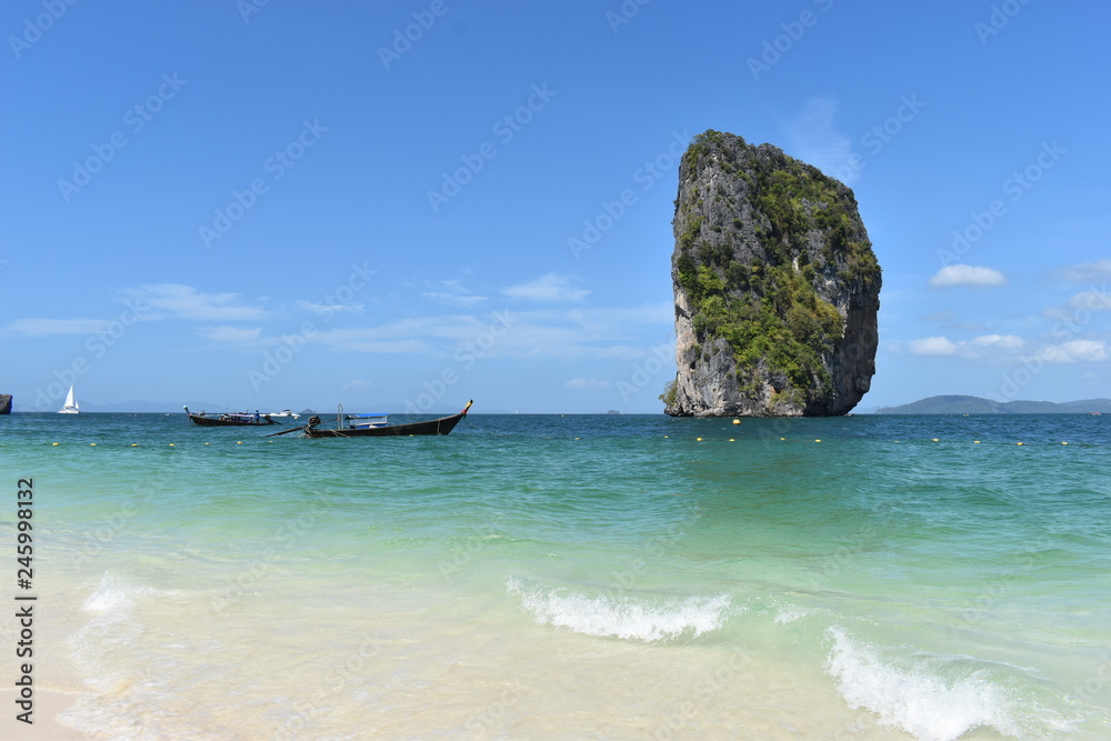 Beautiful big rock at Poda Island and a wooden long tail boat in Krabi, Thailand, Asia
