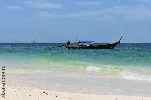 Beautiful lonely beach with a wooden long-tail boat in front at Poda Island in Krabi, Thailand, Asia © places-4-you