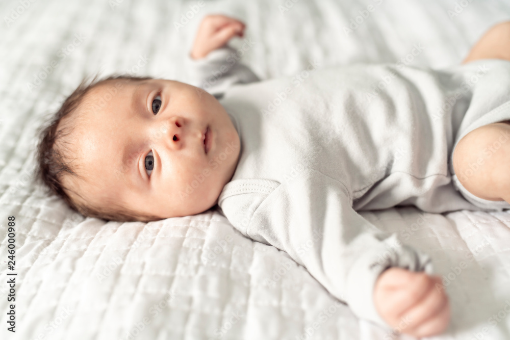 A happy newborn baby on the bed at home A happy newborn baby on the bed at home
