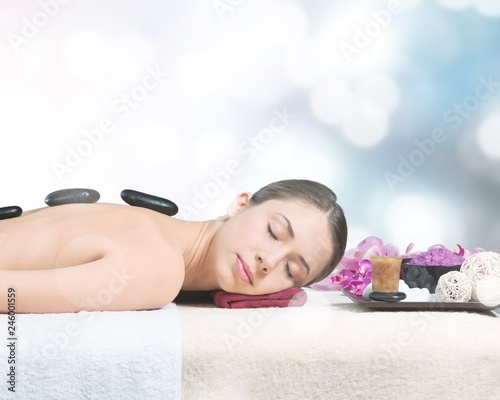 Young woman in spa salon, getting stones massage