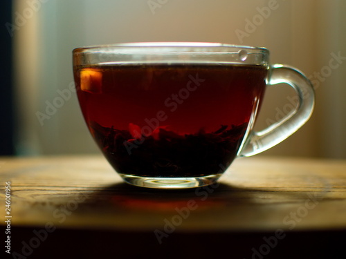 Transparent cup of golden strong tea. Glass cup with tea.