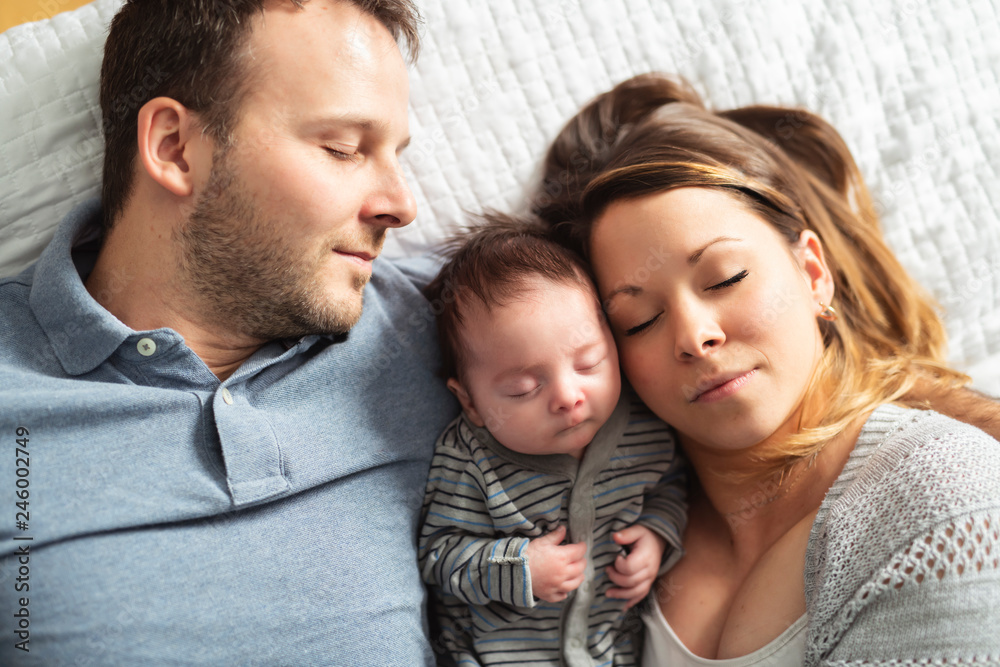 A beautiful couple with newborn Baby on bed.
