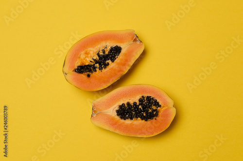 Half fresh ripe papaya on yellow background