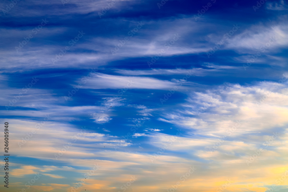 Beautiful and blue, orange, white  feather clouds against the dark sky in sunrise, magic romantic background 