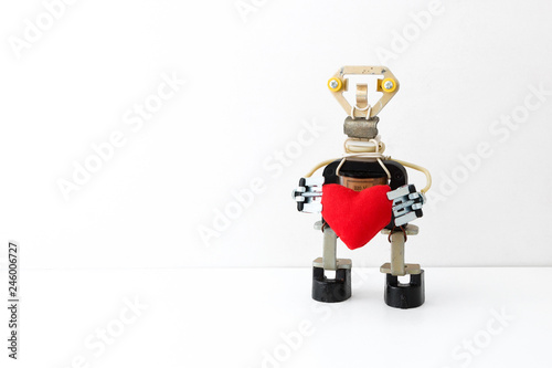 The metal robot holds in hands the heart sewn from fabric. Love. Be my Valentine. St. Valentine's Day. Concept.