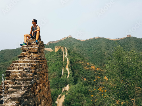 A man sitting on the Great Wall in China. There are still hidden gems at this so popular travel destination. photo