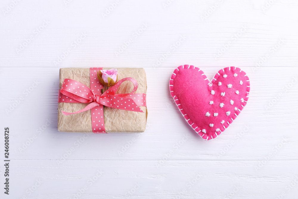Pink felt heart and handmade gift on a white wooden table, Concept, banner, copy space. Pink felt heart and handmade gift on a white wooden table, Concept, banner, copy space.