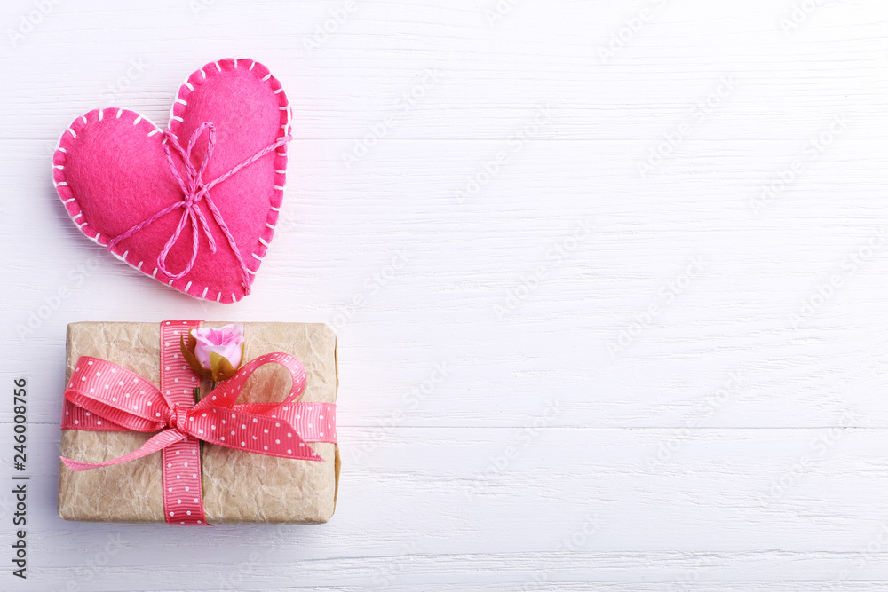 Pink felt heart and handmade gift on a white wooden table, Concept, banner, copy space. Pink felt heart and handmade gift on a white wooden table, Concept, banner, copy space.