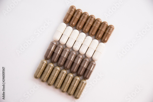 a lot of capsules of tablets lies on a white background